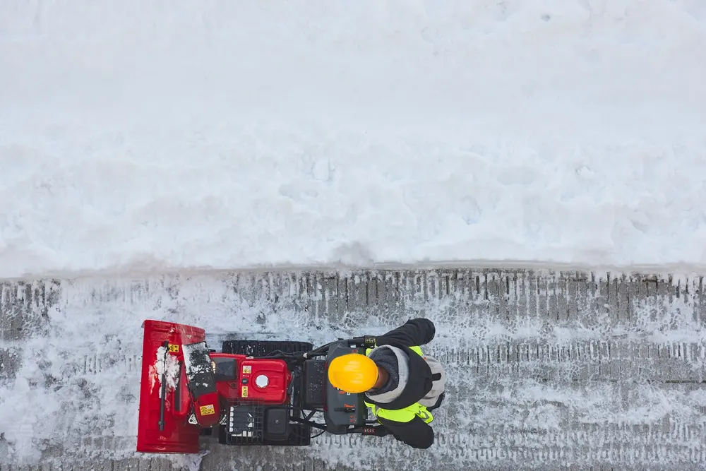 Snow being cleared from a walkway during accumulation